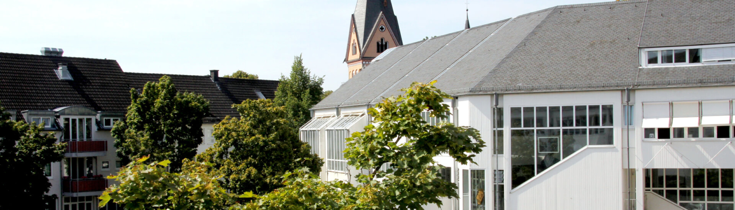 Das Bild zeigt das Rathaus von Bad Honnef mit dem Kirchturm im Hintergrund