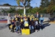 auf dem Schulhof vor der Theodor-Weinz-Grundschule die Schulklassen mit gelben BHAG-Kappen mit Lehrerein, Schulleiterin und Projektleiterin