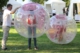 Kinder in Bubblebällen während des Lebensfreudefestivals. Im Hintergrund weiße Pagodenzelte