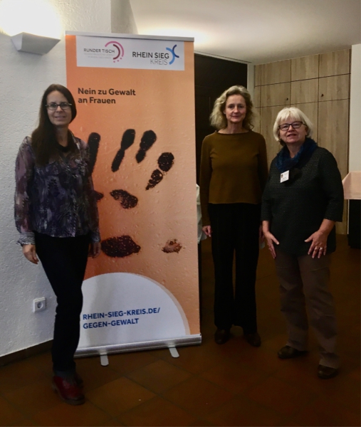 Die Gleichstellungsbeauftragten von Bad Honnef, Königswinter und Meckenheim beim Fachtag vor dem orangen Roll-up "Nein zu Gewalt an Frauen"vor 
