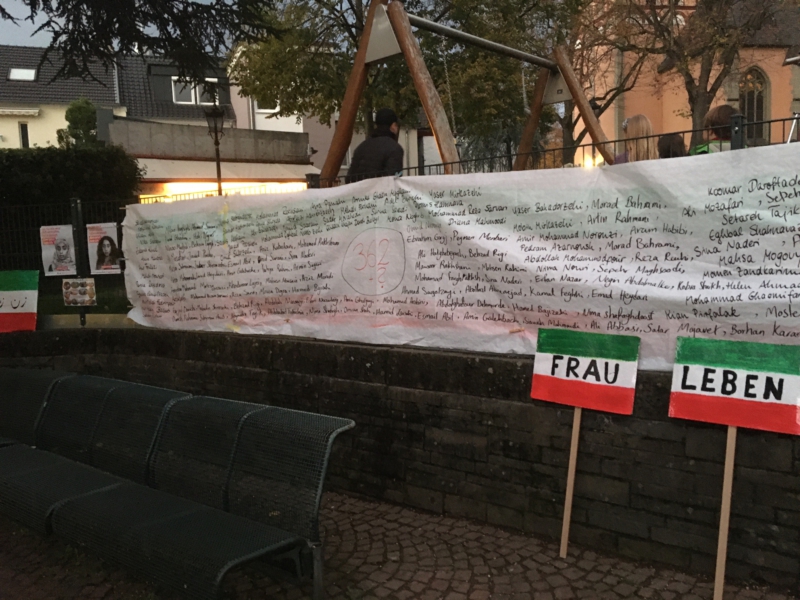 Banner mit Namen von 362 getöteten Personen am Vogelbrunnen
