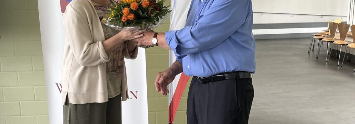 Ein Mann überreicht einer Frau einen Blumenstrauß